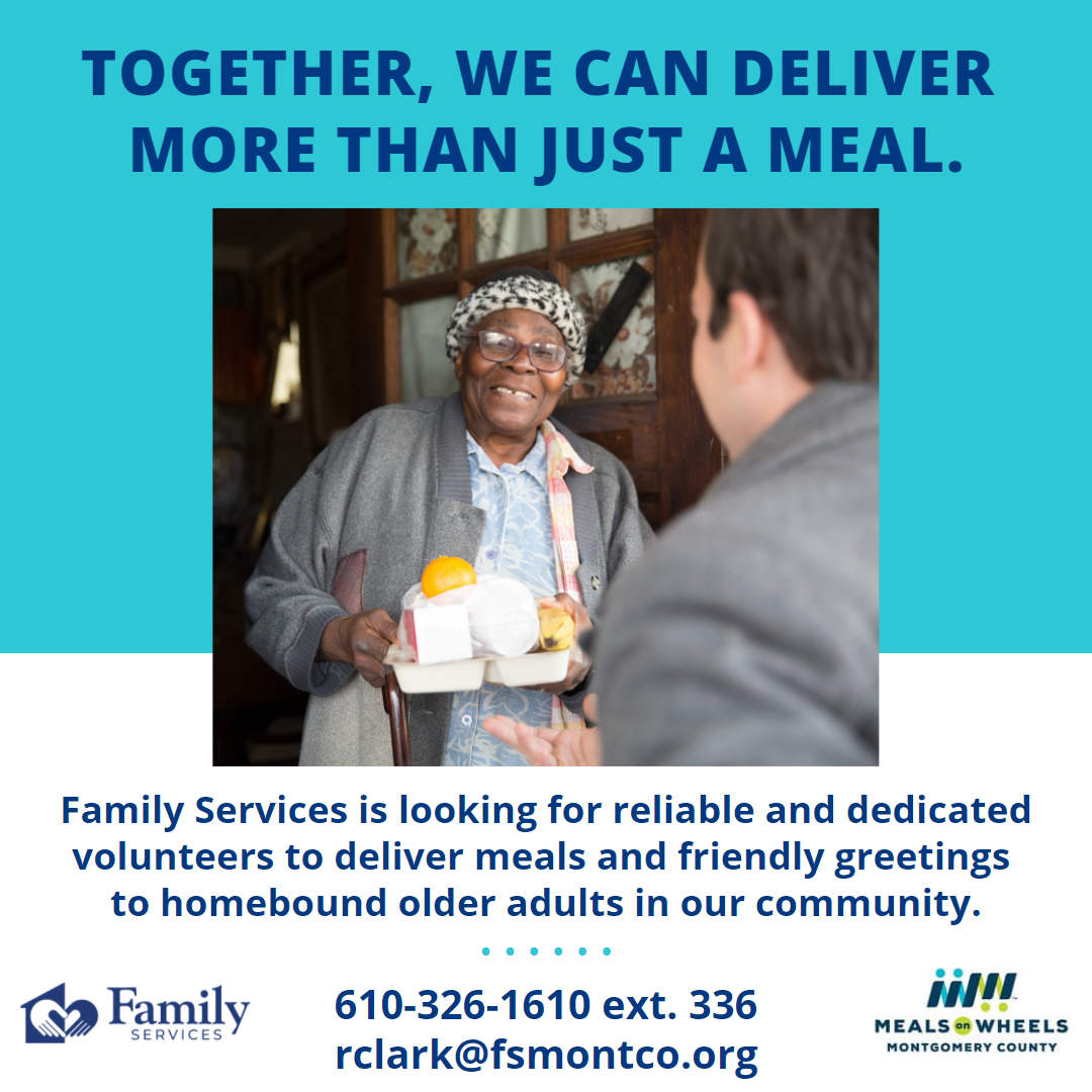 Older woman at front door smiling and holding a meal