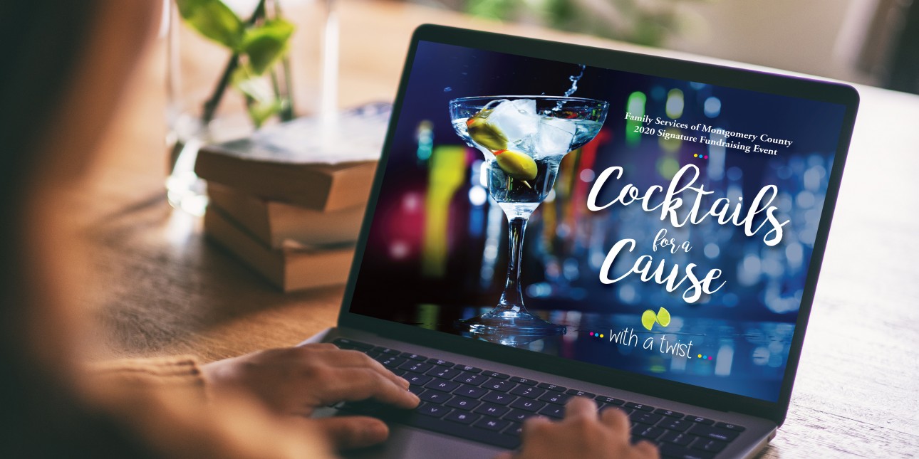 Woman sitting with fingers on laptop keyboard. Image on screen is a cocktail glass with the text "Cocktails for a Cause."
