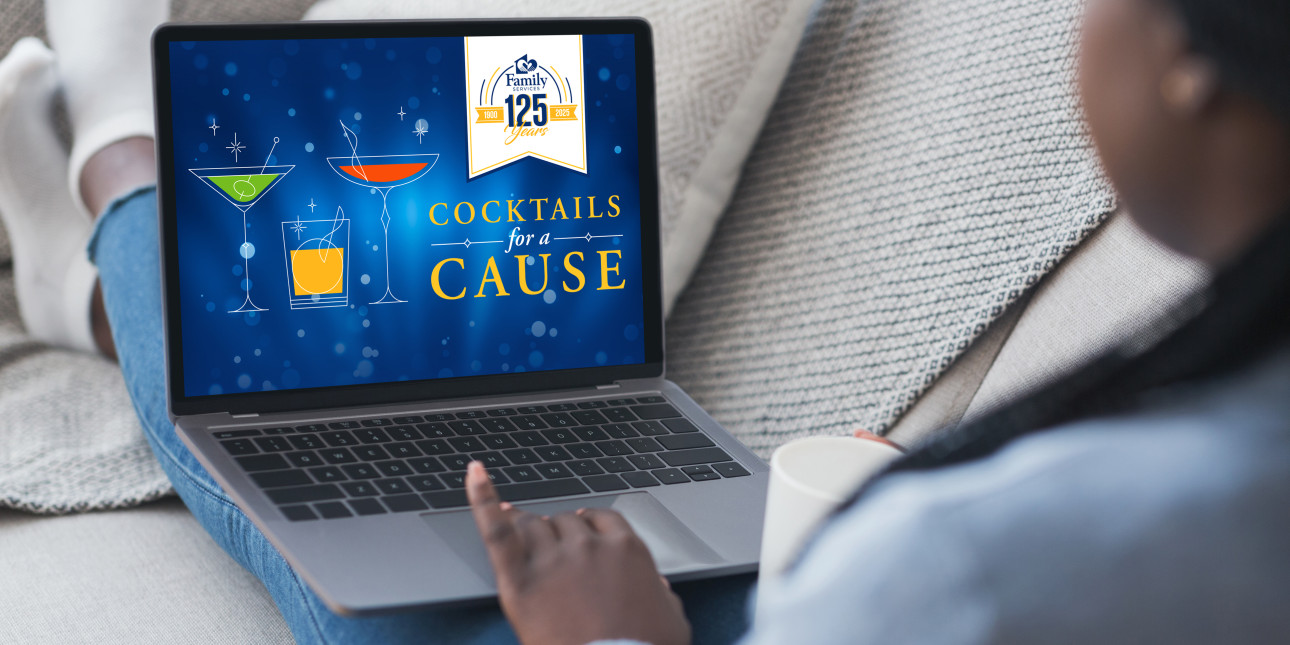 Looking over shoulder of woman sitting on a couch with a laptop on her lap